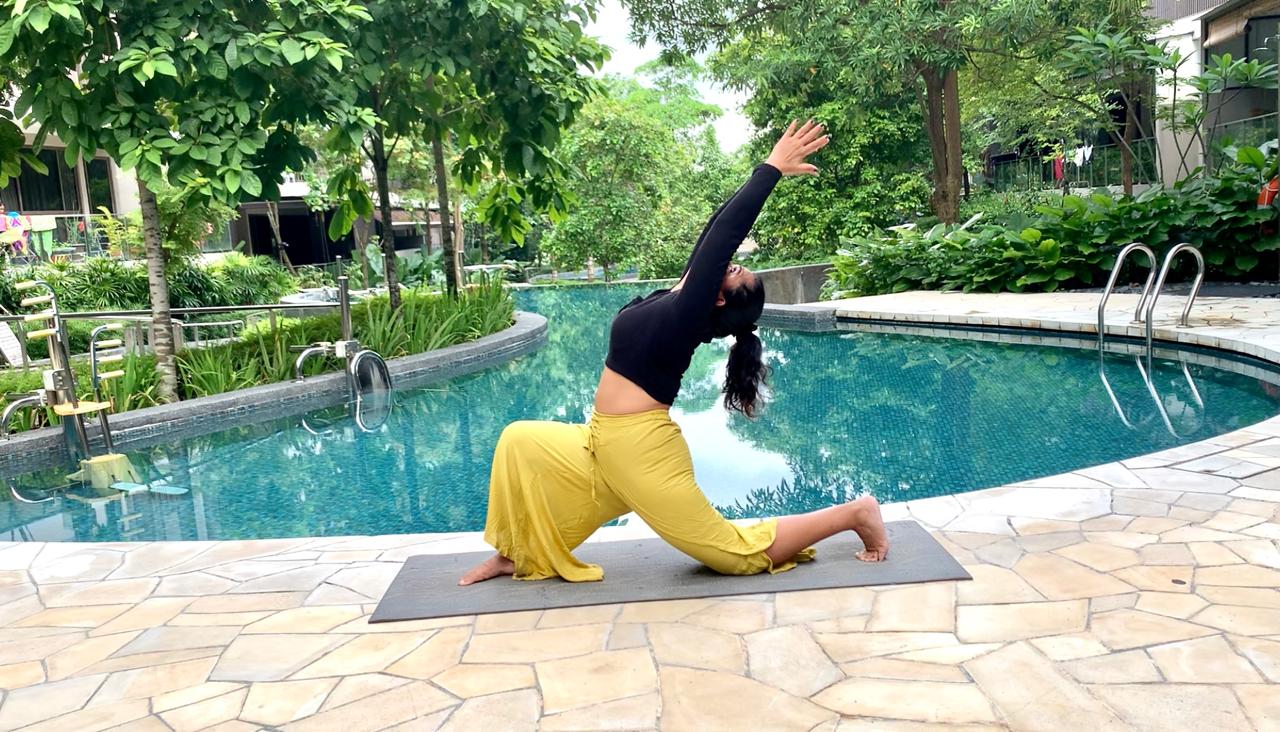 A grounded lunge practised beside a tranquil pool